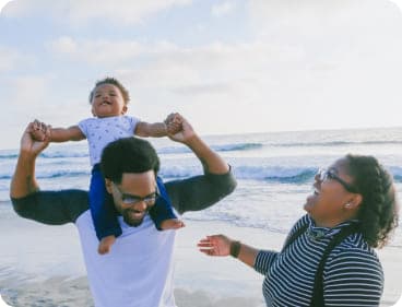 A happy family with a baby on the beach.